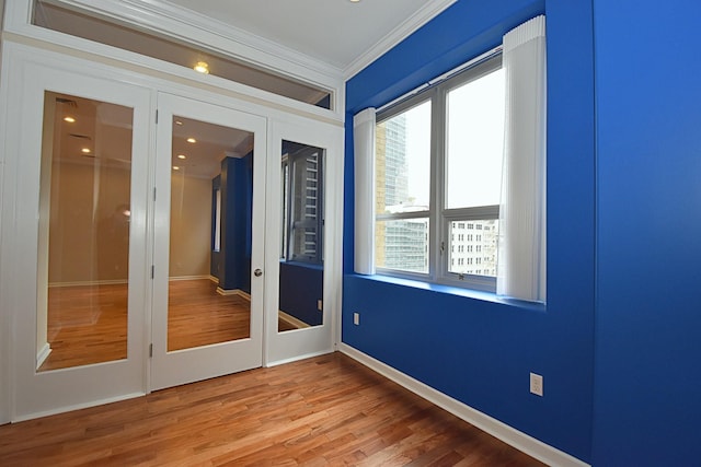 unfurnished room featuring hardwood / wood-style flooring, ornamental molding, and french doors