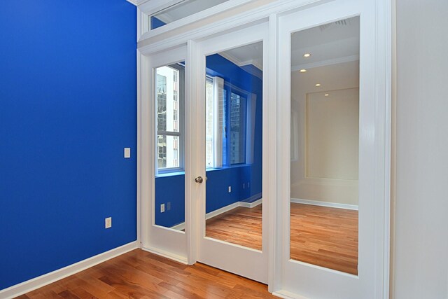 doorway with hardwood / wood-style flooring and ornamental molding