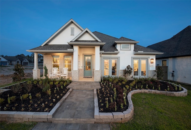 view of front of home featuring french doors and covered porch