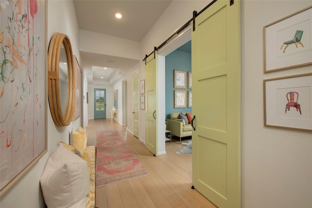 hallway with light hardwood / wood-style floors and a barn door