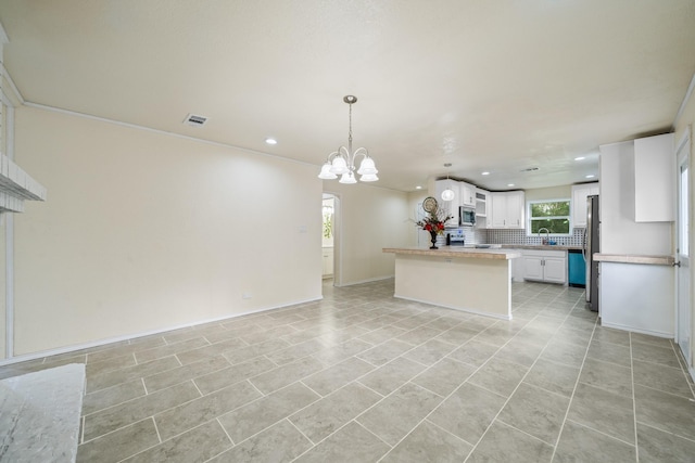 kitchen with sink, white cabinets, tasteful backsplash, a chandelier, and appliances with stainless steel finishes