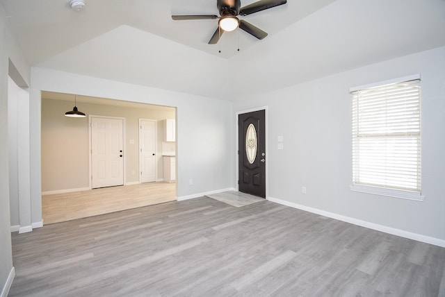 entrance foyer featuring a raised ceiling, light wood-type flooring, ceiling fan, and plenty of natural light