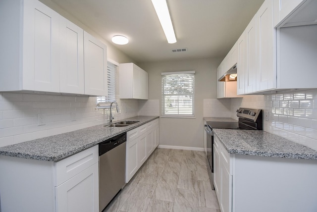 kitchen with stainless steel appliances, decorative backsplash, white cabinetry, and sink