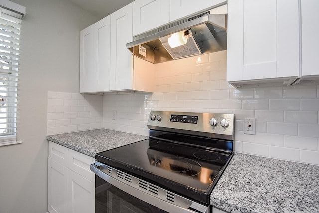 kitchen with electric stove, light stone counters, tasteful backsplash, and white cabinetry