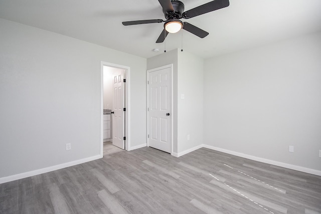 unfurnished bedroom with connected bathroom, ceiling fan, and light wood-type flooring