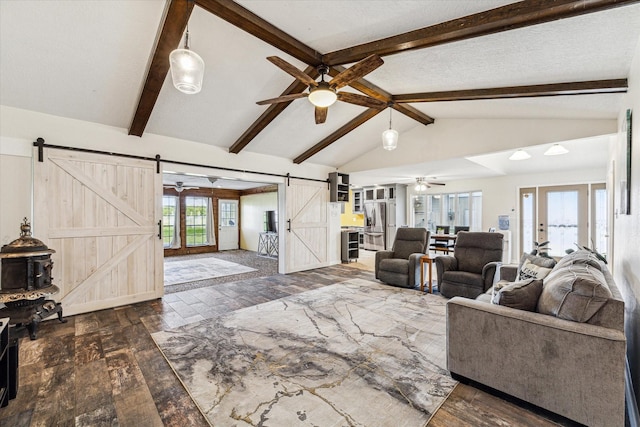 living room featuring french doors, vaulted ceiling with beams, hardwood / wood-style flooring, and a barn door