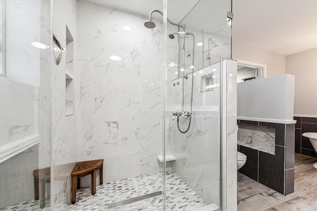 bathroom featuring tile walls, toilet, and walk in shower