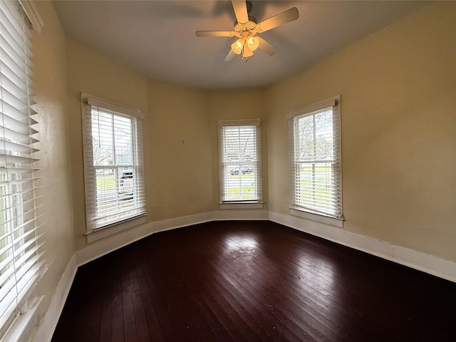 empty room featuring ceiling fan, hardwood / wood-style floors, and a wealth of natural light