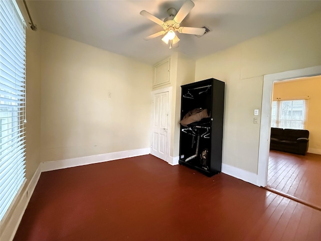 empty room with ceiling fan and dark hardwood / wood-style flooring