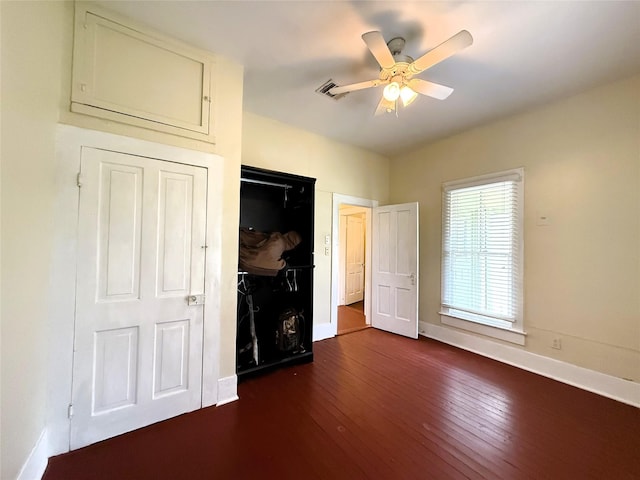 unfurnished bedroom featuring ceiling fan and dark wood-type flooring