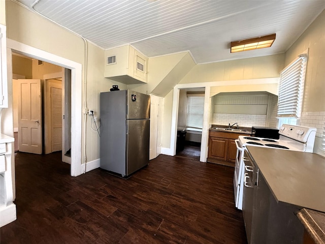 kitchen featuring sink, white range with electric cooktop, tasteful backsplash, stainless steel refrigerator, and dark hardwood / wood-style floors