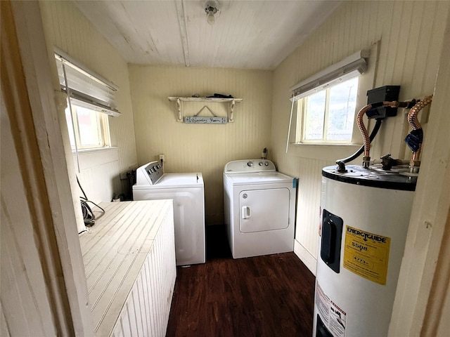 washroom with electric water heater, washer and clothes dryer, a healthy amount of sunlight, and dark hardwood / wood-style floors
