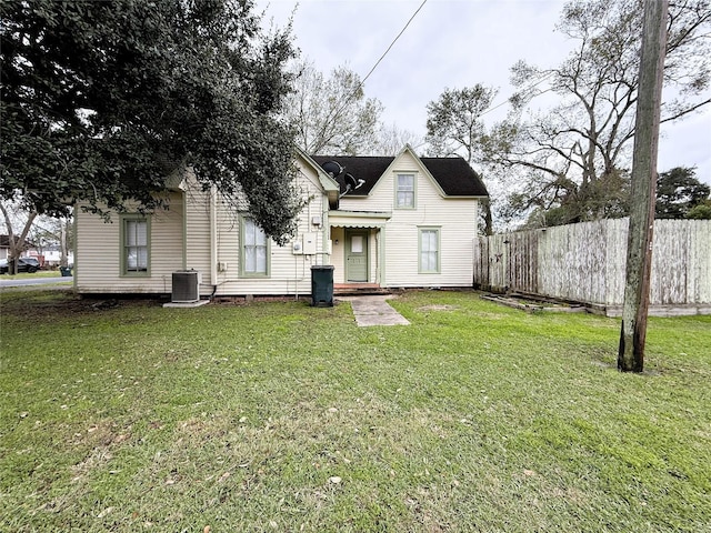 rear view of property with a yard and central air condition unit