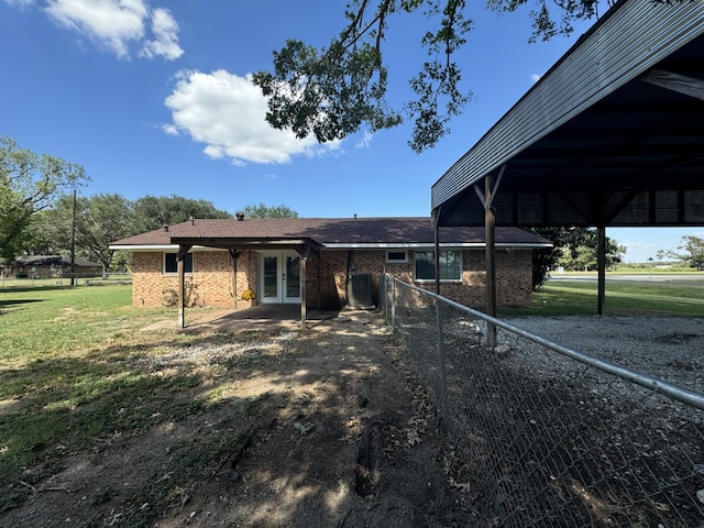 rear view of house featuring french doors and a yard