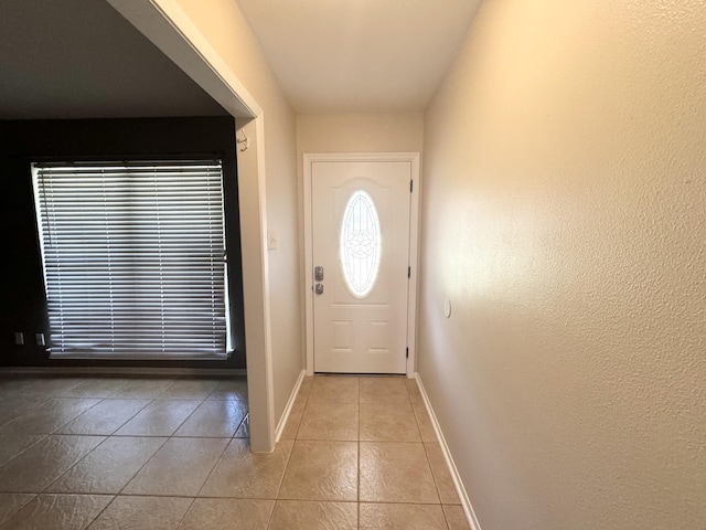 doorway to outside with light tile patterned flooring