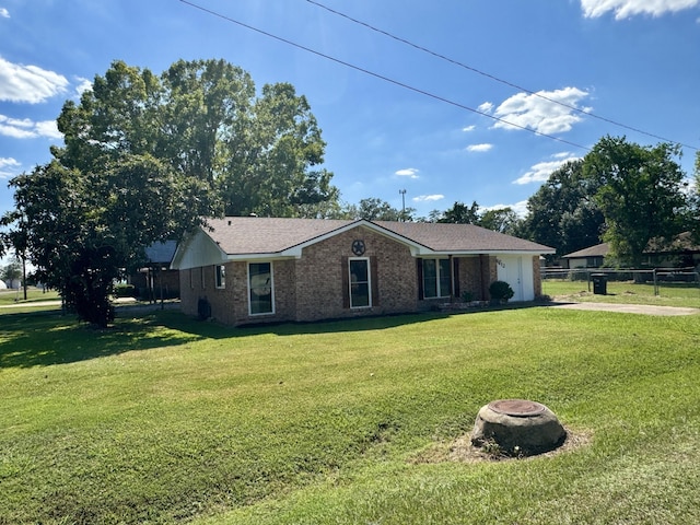 single story home with an outdoor fire pit and a front lawn