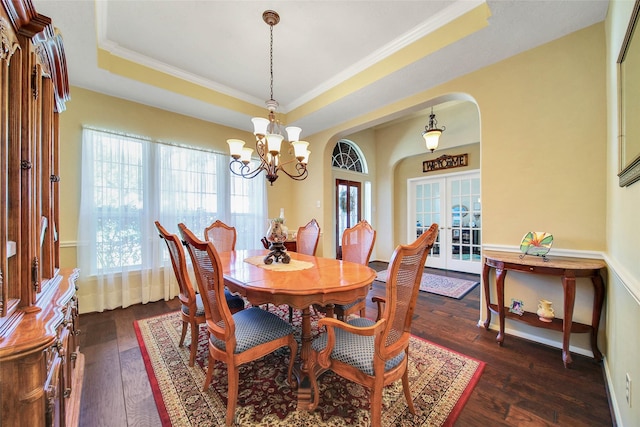 dining room featuring french doors, an inviting chandelier, ornamental molding, dark hardwood / wood-style floors, and a raised ceiling