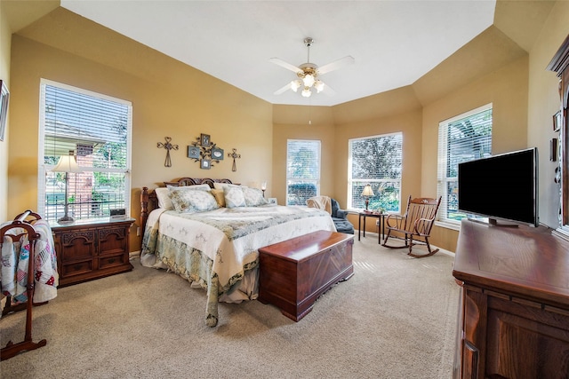 carpeted bedroom featuring multiple windows, vaulted ceiling, and ceiling fan