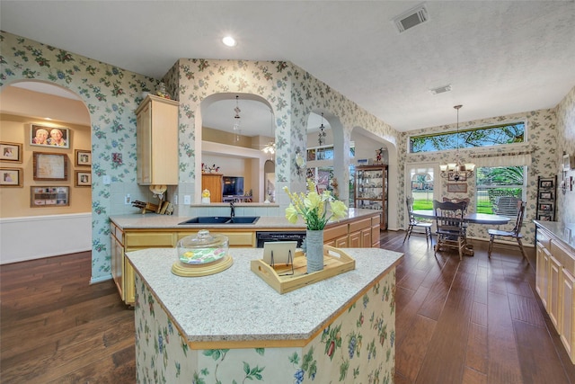 kitchen with light brown cabinetry, sink, dark wood-type flooring, and a kitchen island