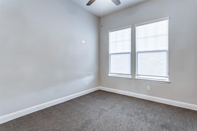 spare room with ceiling fan and dark colored carpet