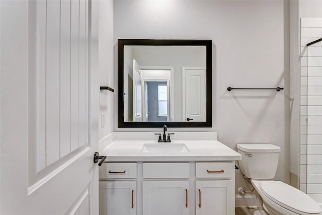 bathroom with toilet, walk in shower, and vanity