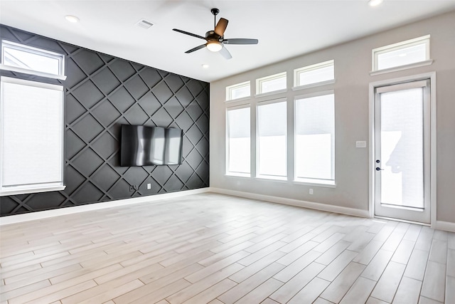 unfurnished living room with ceiling fan and light hardwood / wood-style floors