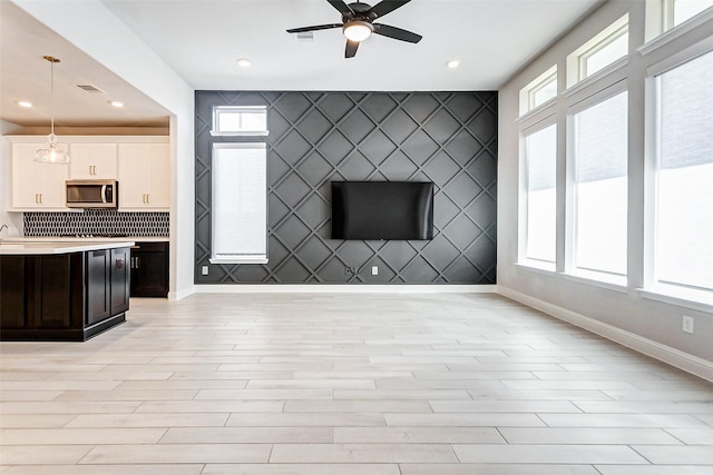 unfurnished living room featuring light hardwood / wood-style floors and ceiling fan