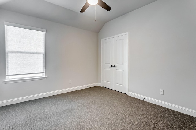 unfurnished bedroom with vaulted ceiling, ceiling fan, a closet, and multiple windows