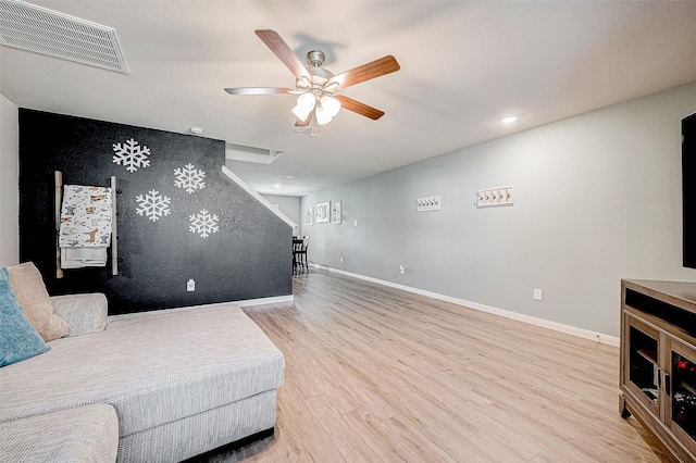 living room featuring ceiling fan and light wood-type flooring