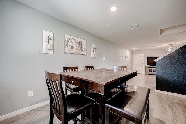 dining room with light wood-type flooring and ceiling fan