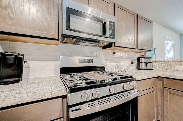 kitchen with stainless steel appliances, decorative backsplash, and light brown cabinetry