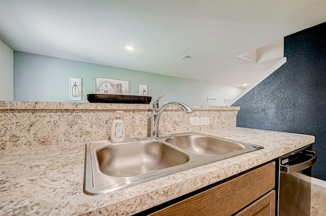 kitchen featuring sink, tasteful backsplash, and dishwasher