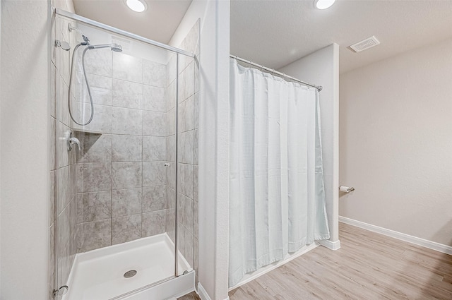 bathroom with hardwood / wood-style flooring and curtained shower