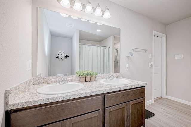 bathroom with hardwood / wood-style flooring, a shower with shower curtain, and vanity