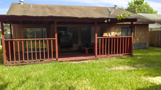 rear view of property featuring a lawn