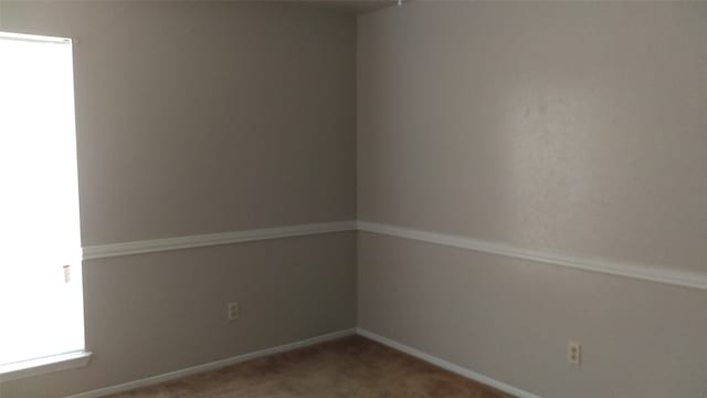 carpeted spare room featuring plenty of natural light