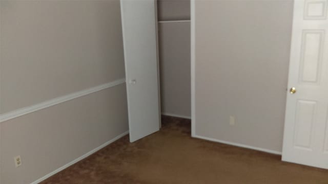 unfurnished bedroom with a closet and carpet floors