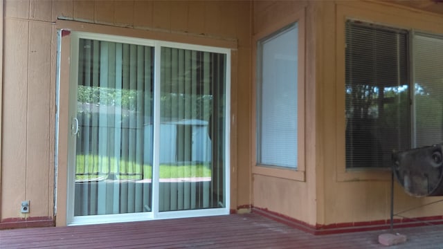 doorway to outside with wood walls