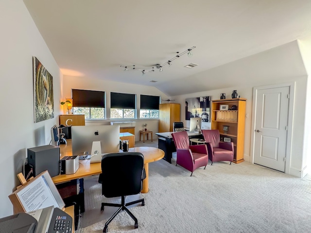 carpeted office space with rail lighting and vaulted ceiling