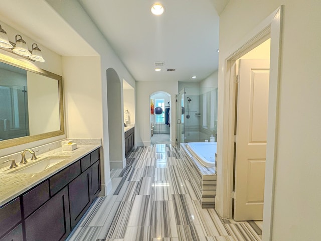 bathroom with independent shower and bath and vanity