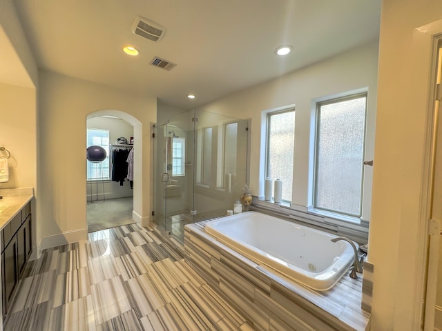 bathroom featuring plus walk in shower and vanity