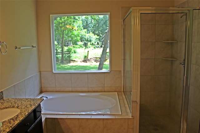 bathroom with a shower stall, vanity, and a bath