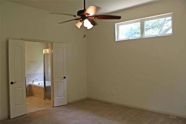 unfurnished bedroom with a ceiling fan, baseboards, ensuite bath, and light colored carpet