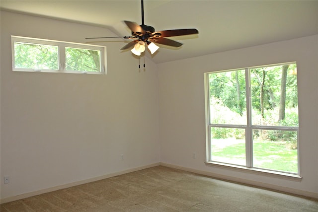 empty room with a ceiling fan, baseboards, and light carpet