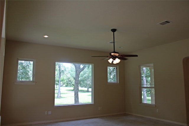 empty room with baseboards, ceiling fan, and visible vents