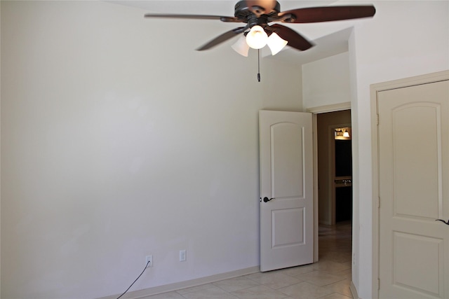 unfurnished room featuring baseboards, ceiling fan, and light tile patterned floors