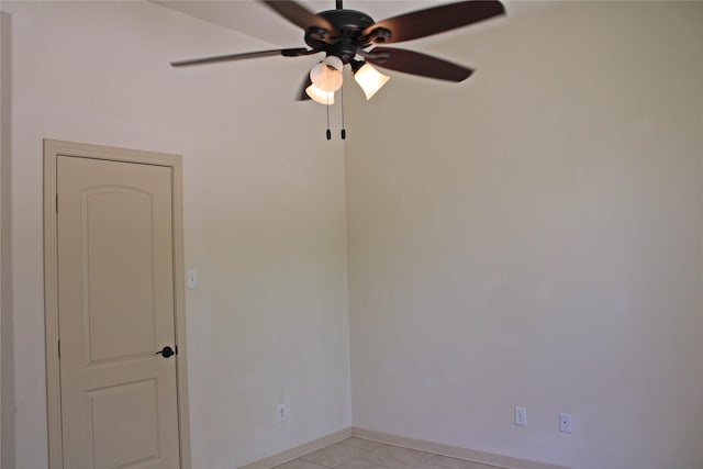 empty room featuring baseboards, ceiling fan, and light tile patterned floors