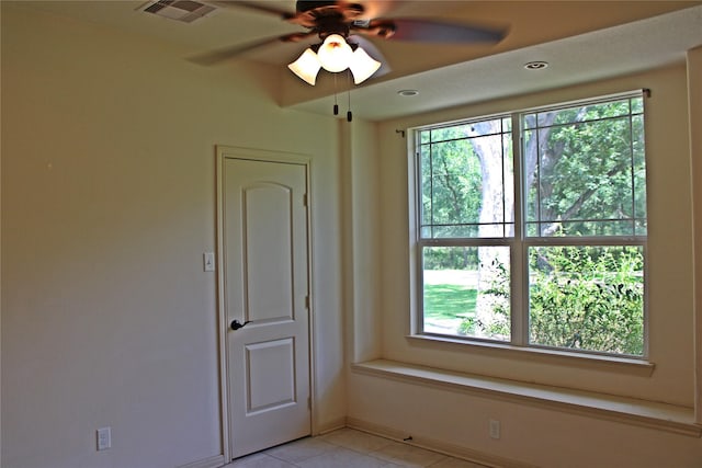 spare room with baseboards, visible vents, light tile patterned floors, and plenty of natural light