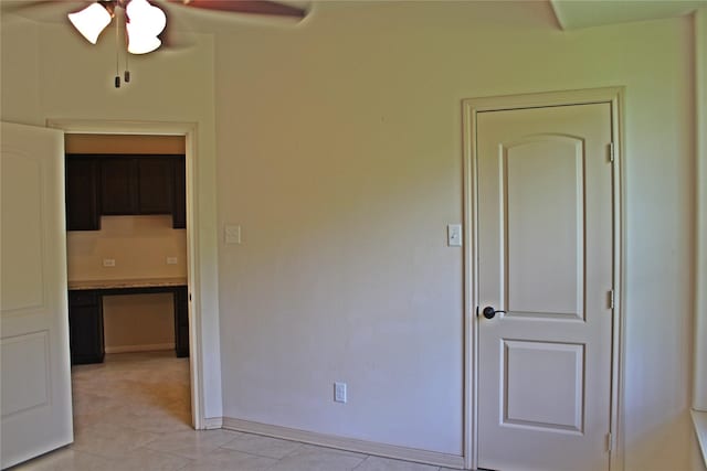 unfurnished room featuring baseboards, a ceiling fan, and light tile patterned floors