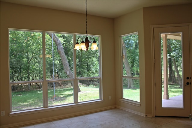 doorway with baseboards, an inviting chandelier, and light tile patterned flooring